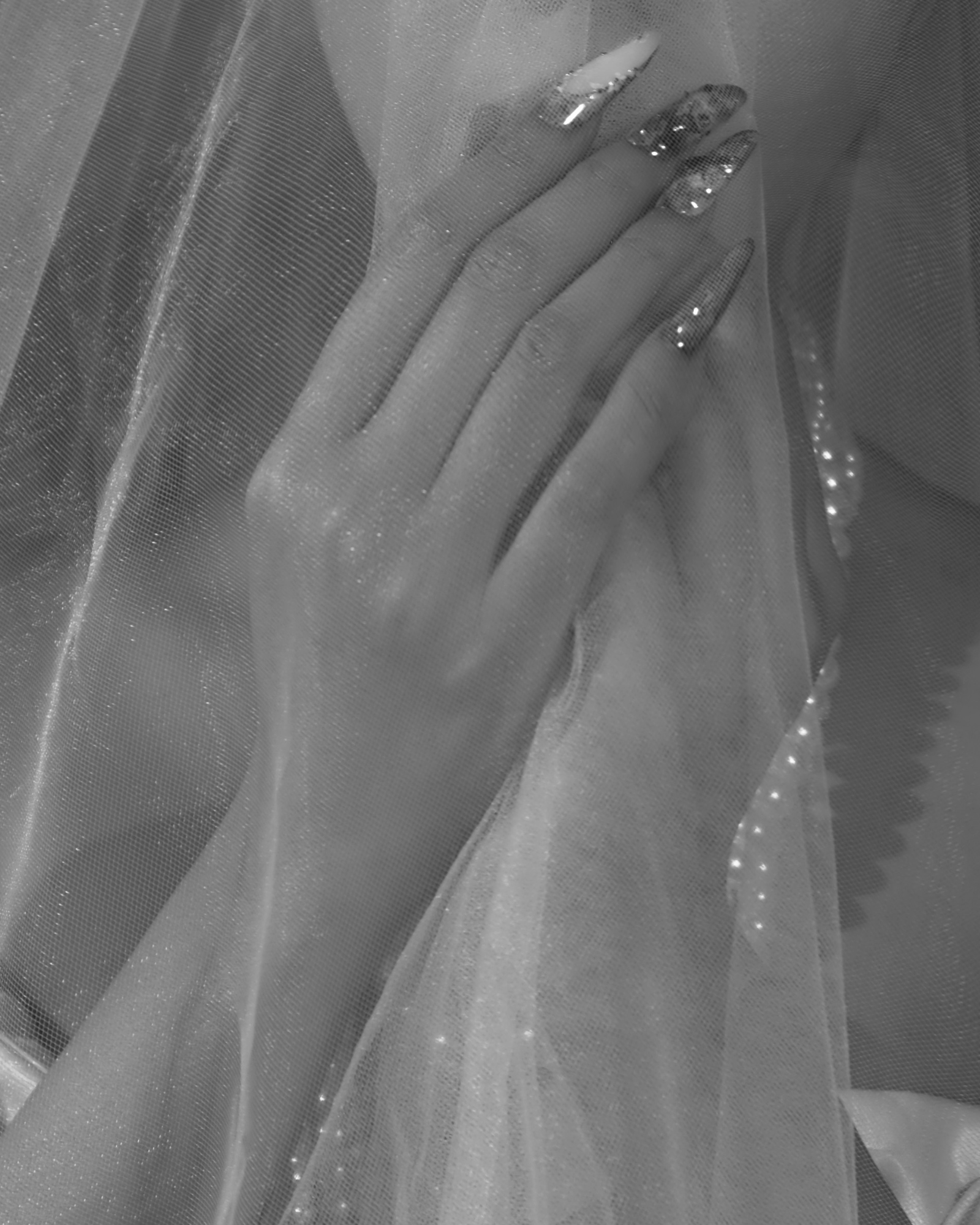 model wearing press-on nail with her hand placing near the veil