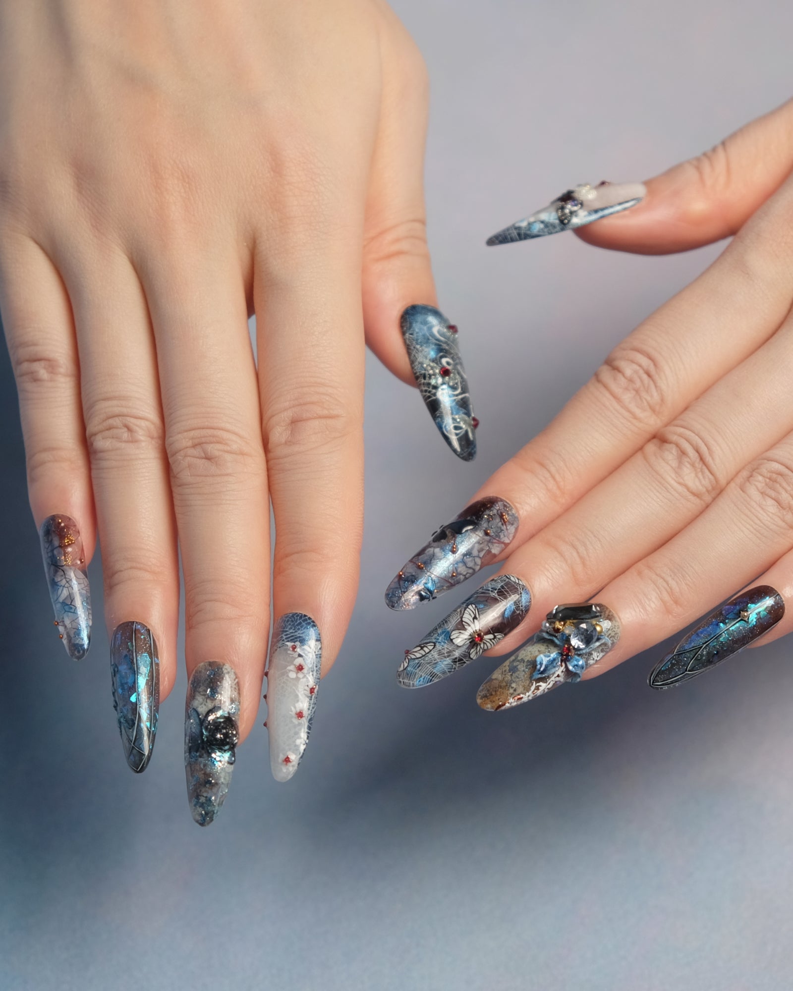Close-up of hands with press-on nail art on a neutral background
