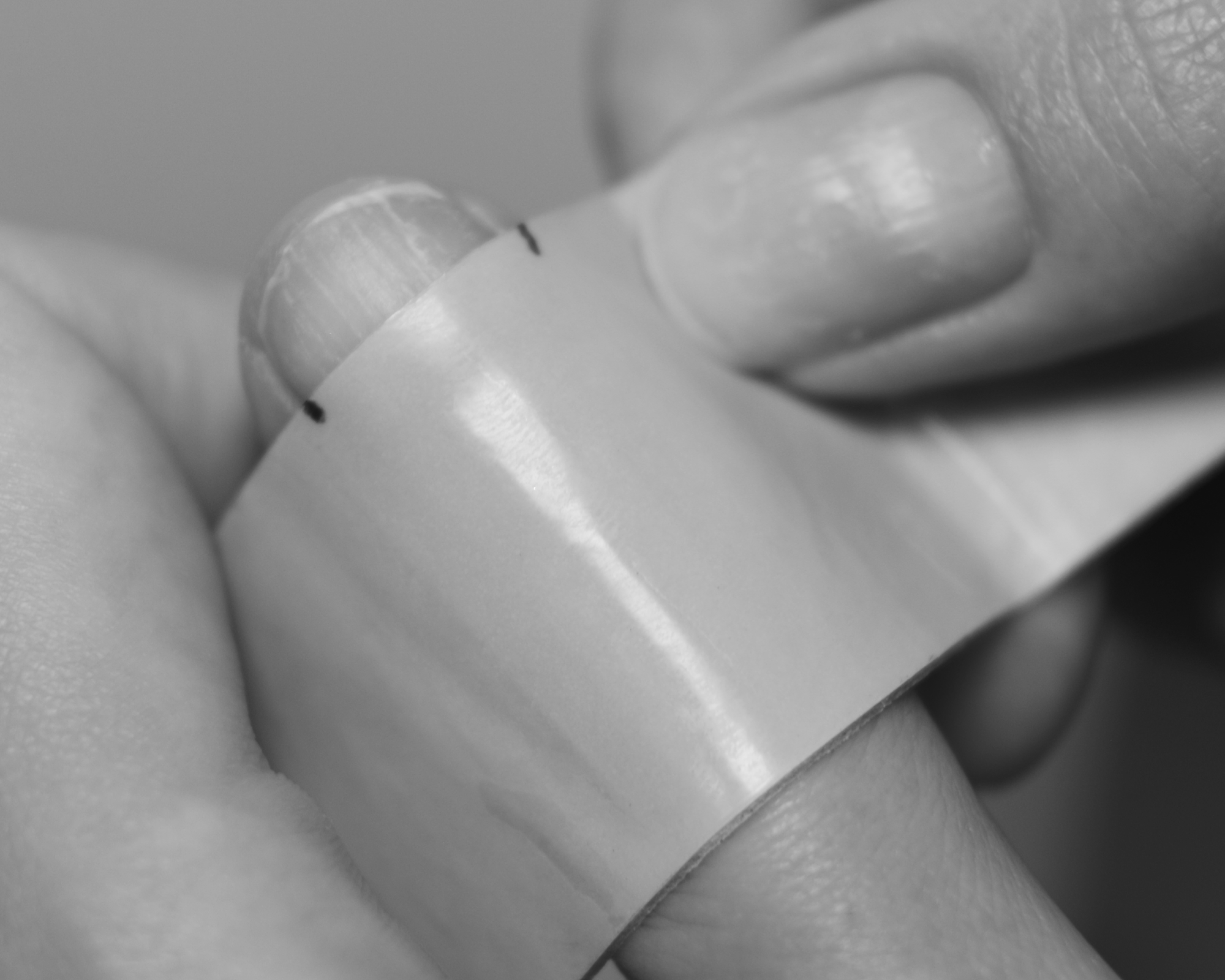 model measuring nail's size with a tape 